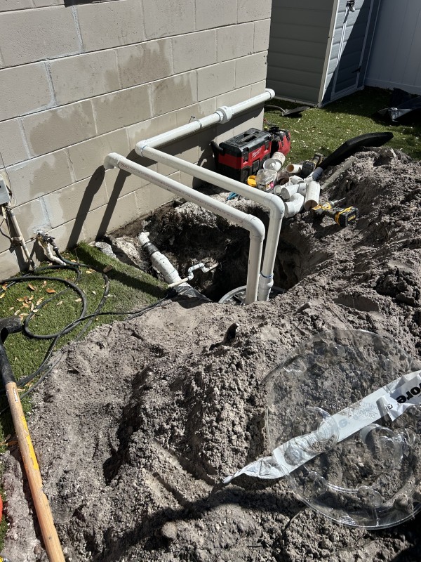 Wide view of underground plumbing and exterior PVC piping