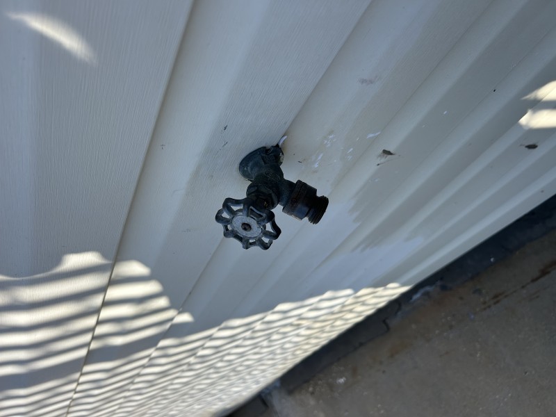 Plumber removing hose bib handle and packing nut using hand tools