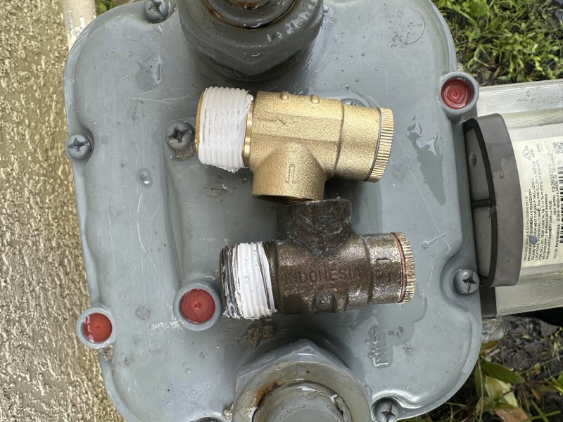 Installing new brass pressure relief valve with PTFE tape and thread sealant