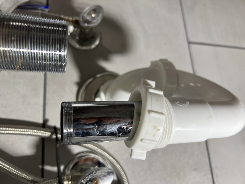 Plumber replacing compression fitting under sink using a basin wrench