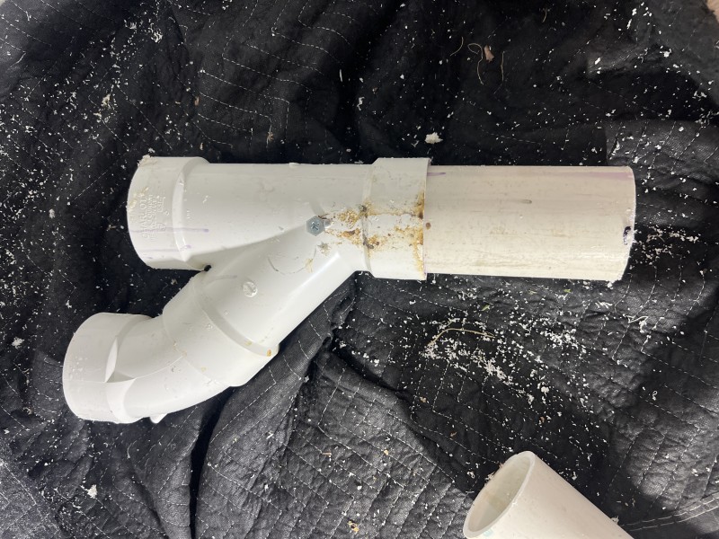 Plumber’s hands repairing the damaged pipe joint with fittings and sealant