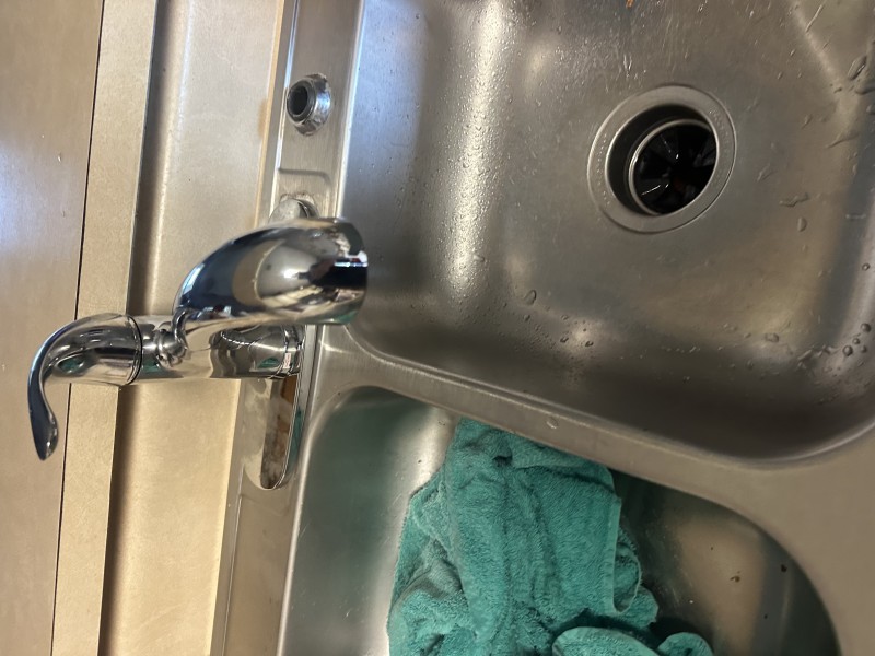 Setting new faucet, aligning gasket, and tightening mounting hardware