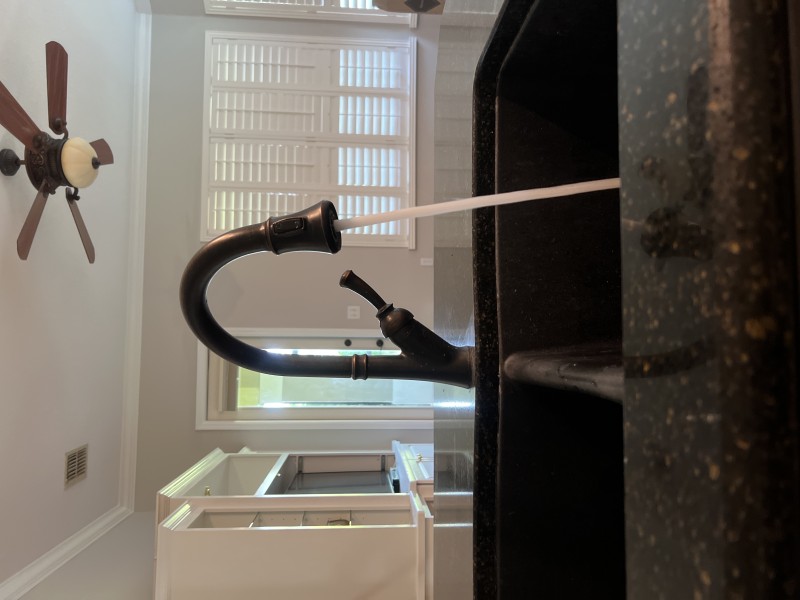 Final walkthrough showing tidy P-trap, aligned slip joints, and labeled shutoffs under the sink
