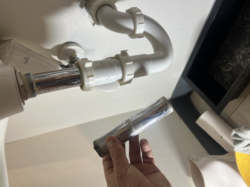 Final under-sink leak test with angle stop valves open and drain under load; joints at trap union remain dry