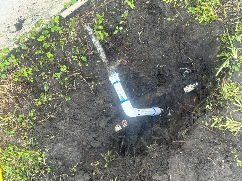 Plumber rerouting PVC piping and pressure testing sprinkler line repair