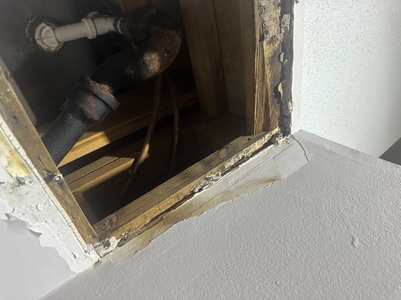 Cutting out corroded cast iron P-trap with reciprocating saw for safe removal