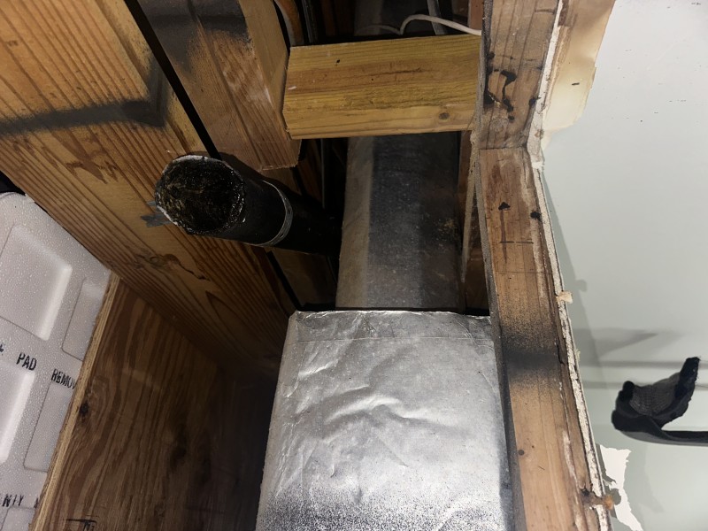 Snaking the tub drain line to remove gunk and debris before new trap installation