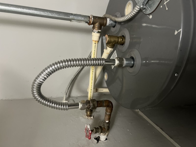 New flexible rigid water heater hose — post-repair New flexible rigid water heater hose installed and tested for leaks
