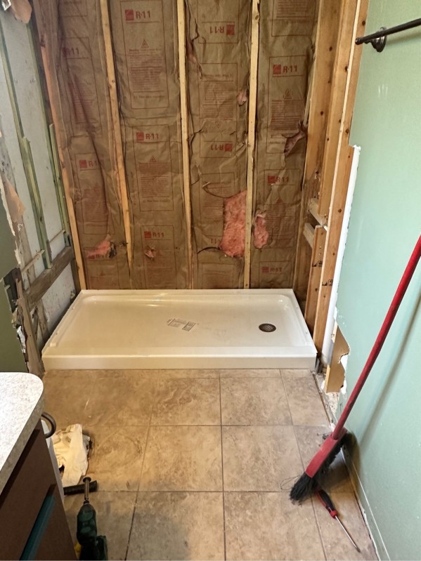 Shower base dry-fit and leveling with mortar bed for proper drain slope