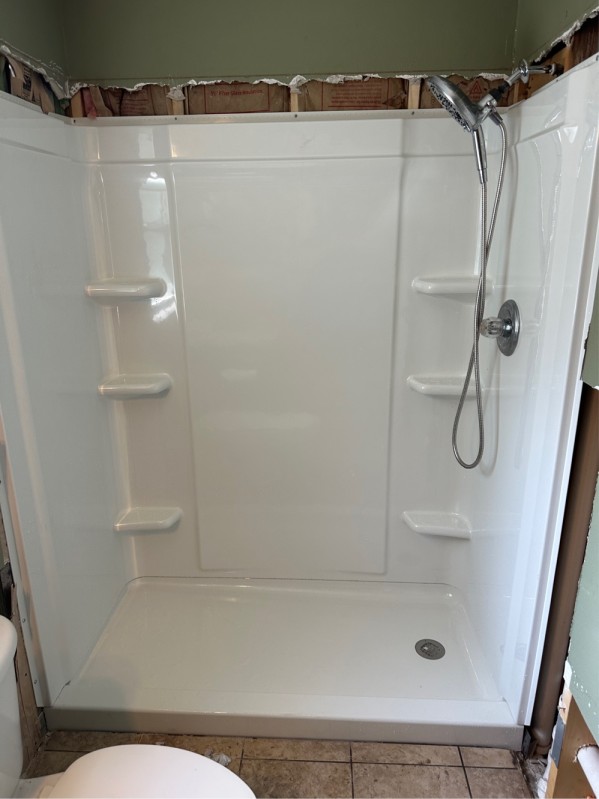 Completed shower walls sealed with silicone and modern trim kit installed