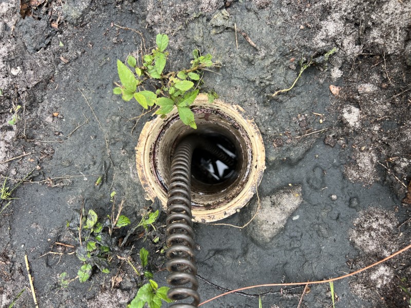 Exterior cleanout near garage used to run high-torque cable and root-cutting head to clear main sewer blockage