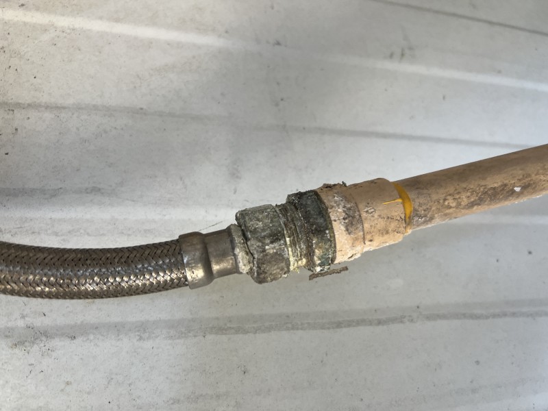 Upper section of the water heater with visible fittings and vent area