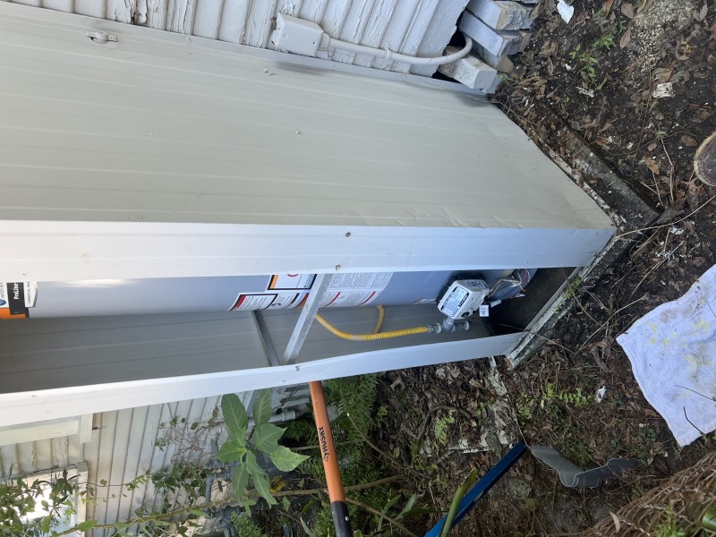 Closer look at the water heater top area with fittings and vent connection visible