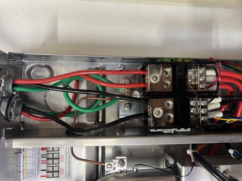 Connecting hot and cold water lines to the tankless unit with copper elbows