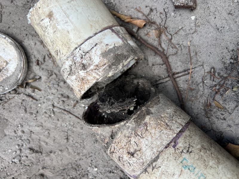 New PVC sewer pipe sections being laid out and aligned in the trench