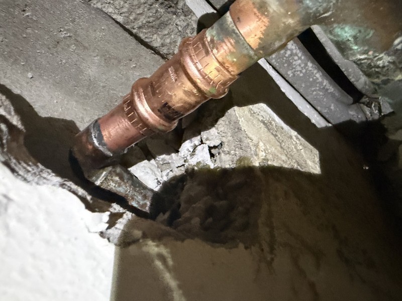 Plumber completing a copper pipe repair with a new 3/4 inch copper section soldered in place