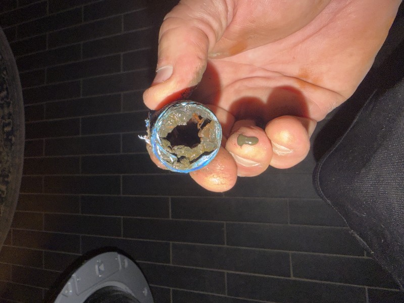 Nipple extractor tool removing a corroded galvanized nipple from a wall fitting during plumbing repair