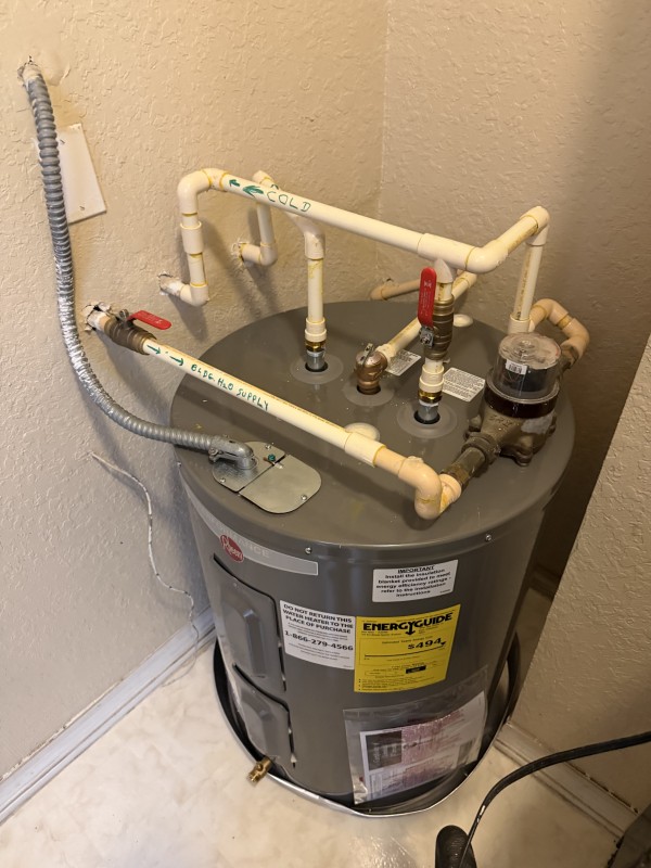 Newly installed electric water heater placed in a drain pan with updated plumbing connections, Riverview, FL, December 11, 2025