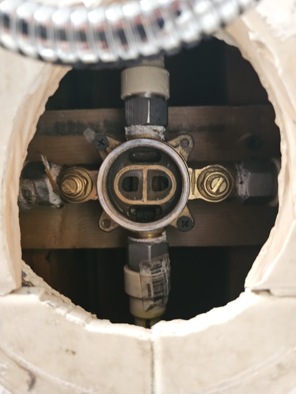 Inside view of the shower valve body showing hot and cold ports during repair, Spring Hill, FL, December 2025