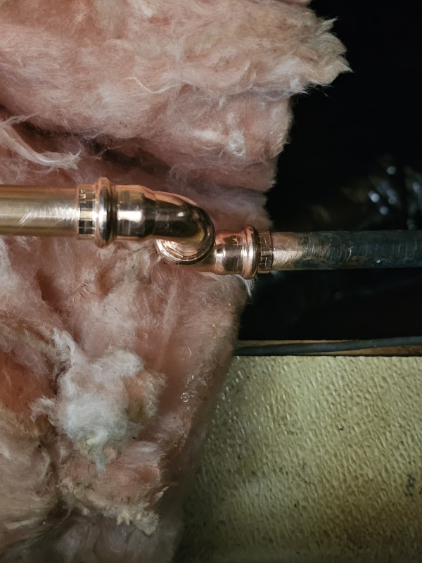 Close-up of a copper press elbow connection installed during a commercial water line repair, Brandon, FL, December 2025