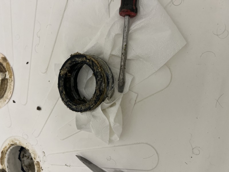 Removed rubber drain gasket and tools used during shower drain repair, Zephyrhills, FL, December 2025