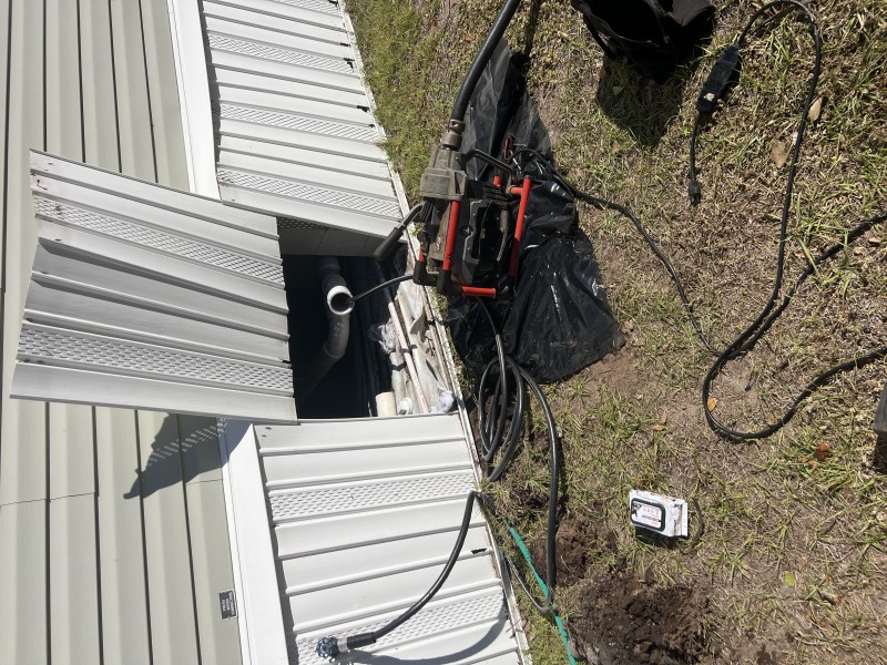 Drain cleaning machine operating outdoors near the home while cabling the main sewer line to clear a blockage, Tampa, FL, February 4, 2026