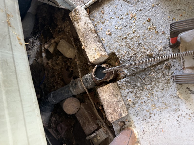 Rubber elbow fitting removed from drain line showing heavy debris buildup causing blockage, Tampa FL February 5 2026