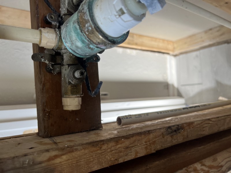 Opened wall cavity view showing the shower valve body and supply lines during leak detection behind the shower handle, Seffner, FL, February 9, 2026