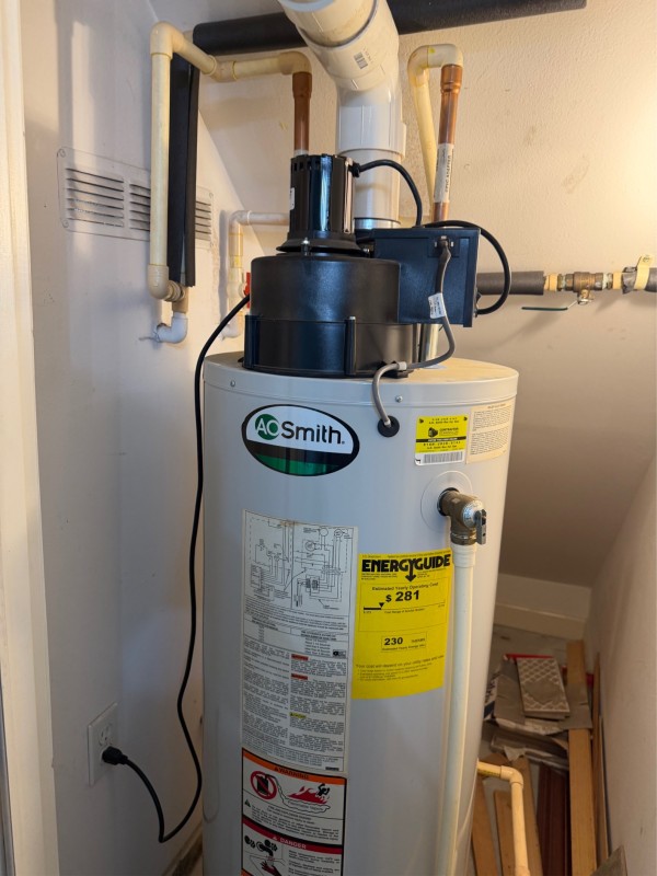 Full view of the existing power-vent gas water heater and vent piping before removal, Tampa, FL, February 2026