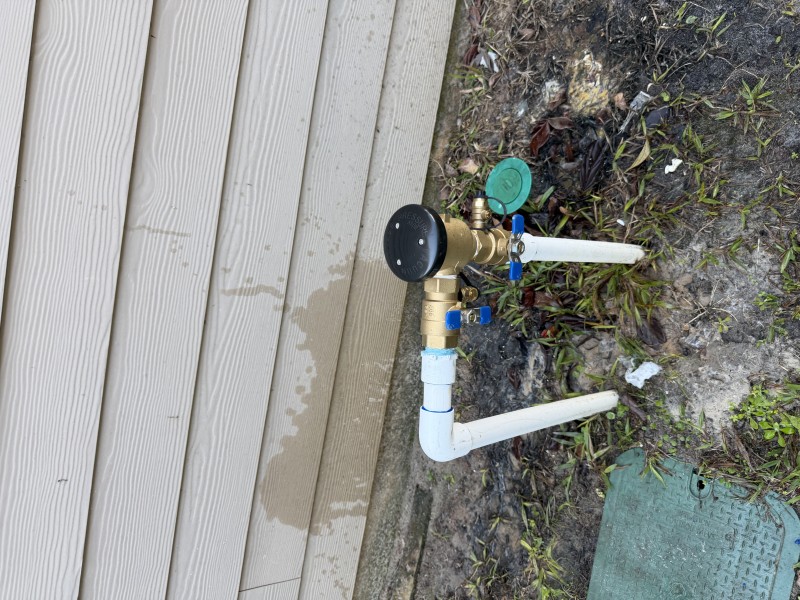 New brass 1 inch RPZ backflow preventer installed on exterior plumbing with final inspection and leak testing completed, Ocala FL February 2026