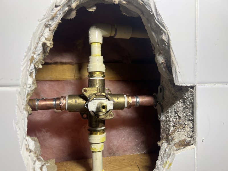 Exposed shower plumbing and old Sterling valve body inside the wall before installing the new valve, Tampa, FL, March 2 2026