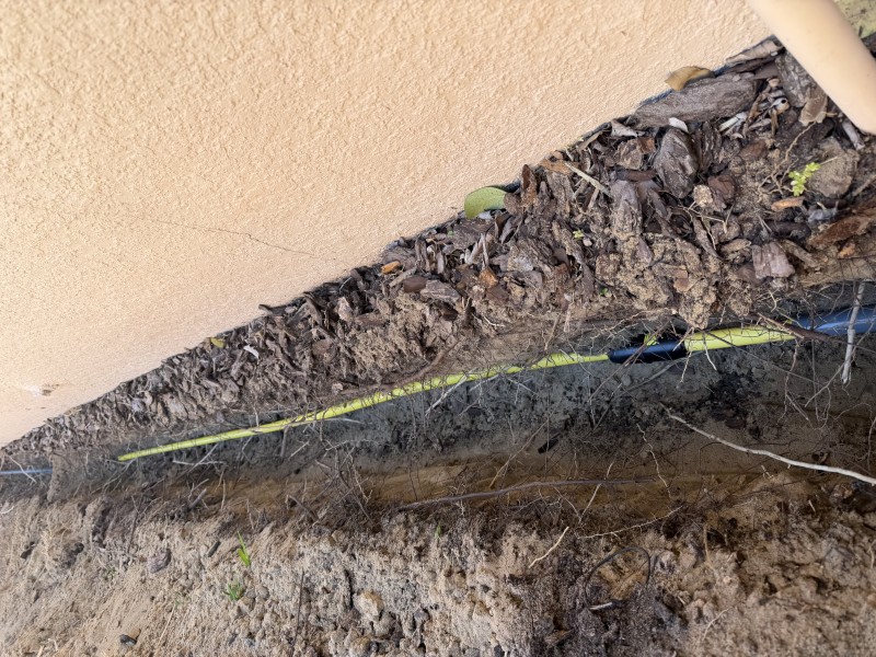 Excavated trench running alongside the home to expose the buried gas line path, Davenport, FL, March 2026
