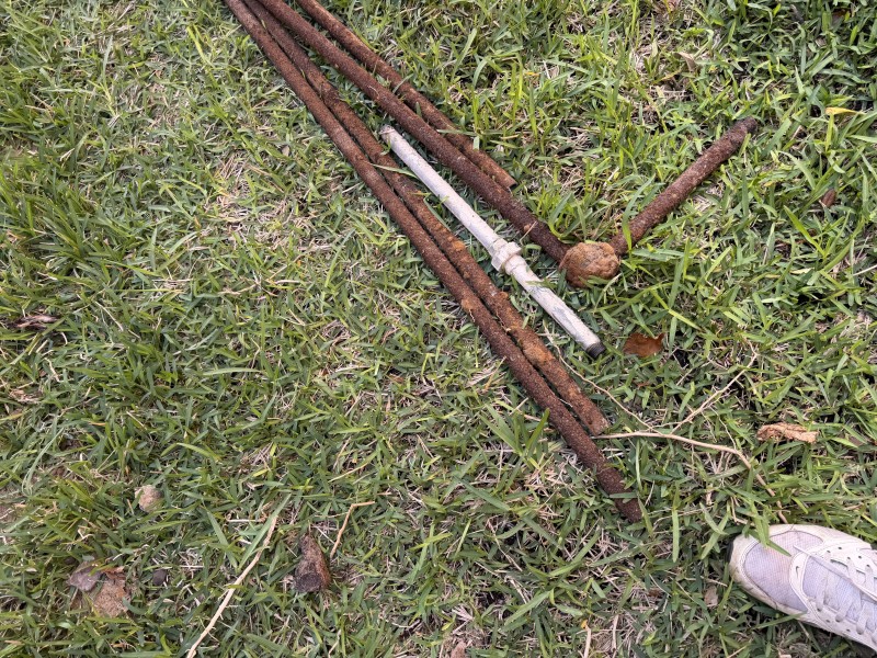 Removed rusted gas pipe sections laid out on the grass after replacement work, Davenport, FL, March 2026