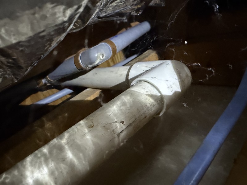 Open ceiling cavity showing active plumbing lines and leak area inside framing, Land O' Lakes, Florida, March 2026