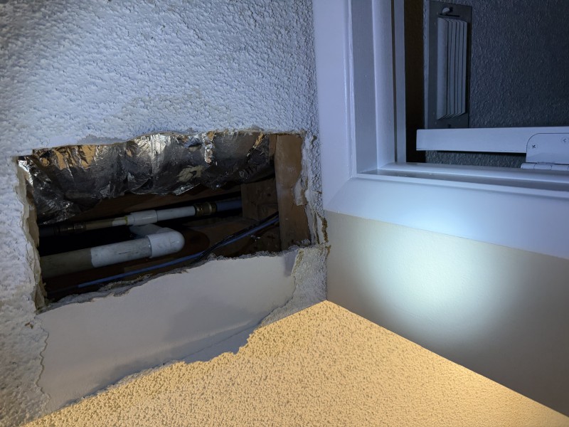 Ceiling opening with repaired plumbing line visible after leak repair completion, Land O' Lakes, Florida, March 2026