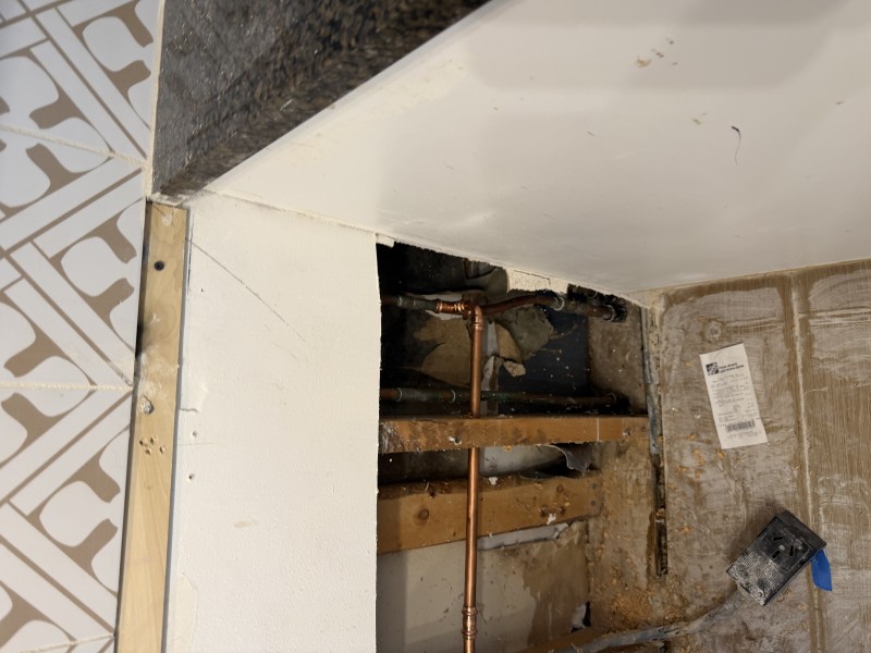 Opened wall cavity showing plumbing reroute path and connection points near bathroom area, Tampa, FL, March 2026