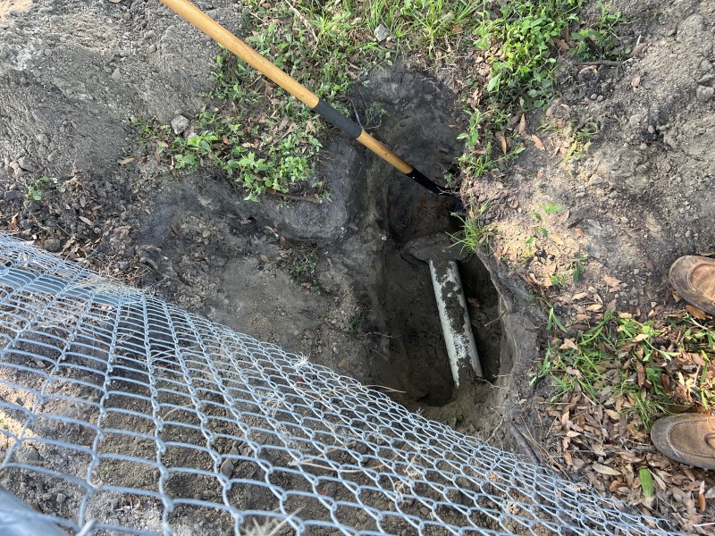 Excavation exposing sewer line and pipe connection near structure, Florida, March 2026