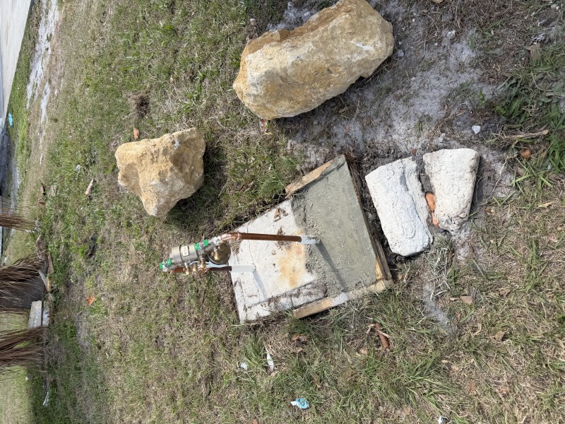Protective boulders installed around backflow preventer to prevent vehicle damage, Sarasota FL, April 2026