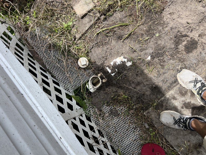 Close-up of completed main drain pipe connections and fittings showing finished repair and cleanout access — Polk City, FL, April 2026