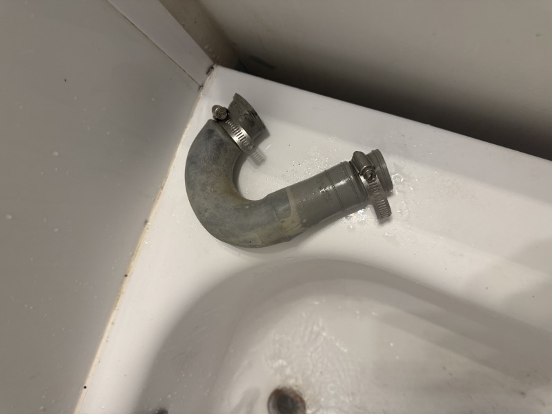Old chrome P-trap removed from bathroom sink showing worn deteriorated trap hardware pulled during drain repair, Tampa FL, April 2026